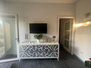 sala de estar con TV en la pared en Acquamarina Luxury Rooms en Budoni
