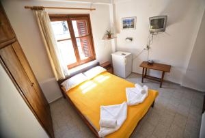 A bed or beds in a room at To Gefyraki Rooms