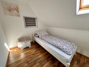 1 dormitorio pequeño con 1 cama y suelo de madera en Ländlicher Rückzugsort: Entspanne dich hier, en Hatten