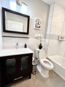 La salle de bains est pourvue de toilettes, d'un lavabo et d'un miroir. dans l'établissement 306 Deluxe double Queen suite in the center city, à Philadelphie