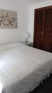 1 dormitorio con 1 cama blanca grande en una habitación en Torre del Plata II, en Punta del Este