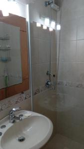 y baño con lavabo y ducha con espejo. en Torre del Plata II, en Punta del Este