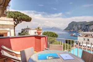 a balcony with a table and chairs and a view of the ocean at Palatium Mari in Capri