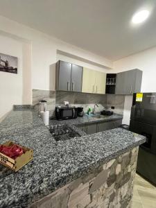 a kitchen with a granite counter top with a stove at Moderno apto familiar piso 2 in Santa Rosa de Cabal