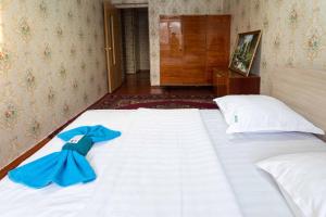 a large white bed with a blue bow on it at Самара in Petropavlovsk