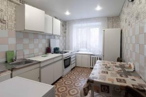 a kitchen with white appliances and a table in it at Самара in Petropavlovsk