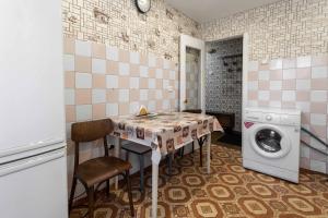 a kitchen with a table and a washing machine at Самара in Petropavlovsk