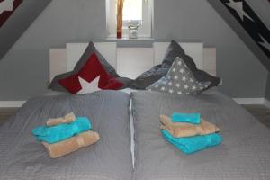 ein Bett mit zwei Handtüchern und Kissen darauf in der Unterkunft Ostseeresidenz Pelzerhaken in Pelzerhaken