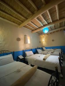 two beds in a room with blue walls at Auberge Agoudal in Agoudal