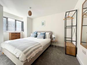 a bedroom with a large bed with blue pillows at Exceptional 3 bedroom home in Penzance~New~Seaside in Penzance
