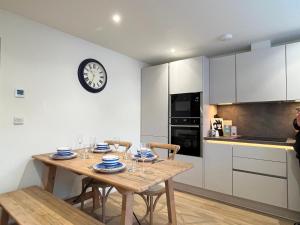 a kitchen with a table and chairs and a clock on the wall at Exceptional 3 bedroom home in Penzance~New~Seaside in Penzance