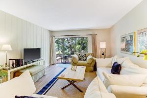 a living room with white furniture and a large window at 2060 Beach Wood in Amelia Island