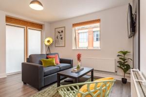 a living room with a couch and a table at Stunning Brand New One Bed City Apartment in Leicester