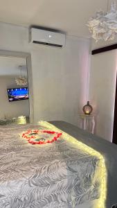 ein Schlafzimmer mit einem Bett mit roten Blumen darauf in der Unterkunft Castelo Pink Boutique Hotel in Uruau