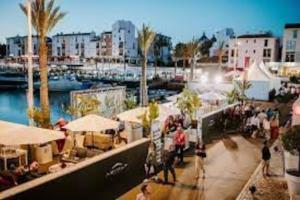 un groupe de personnes marchant sur un trottoir près d'une marina dans l'établissement Apartamento minimalista Centenário, à São Brás de Alportel