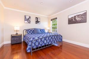 a bedroom with a bed with a blue comforter and a window at Lavender house near Napa and San Francisco in Vallejo