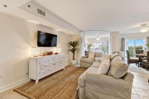Una sala de estar con un sofá y un televisor. en 201 Terraces at Beachside, en Amelia Island
