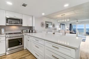 a kitchen with a white counter top and a living room at Amelia South C3 in Amelia Island