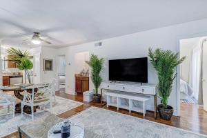 a living room with a flat screen tv and plants at Amelia Landings 6C in Amelia Island