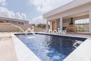 a villa with a swimming pool and a house at Casa com piscina e churrasqueira com linda vista in Itupeva