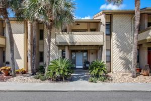 a building with palm trees in front of it at Sea Castles #3 in Amelia Island