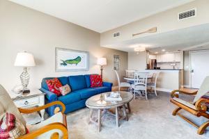 a living room with a blue couch and a table at 247 Sandcastles in Amelia Island