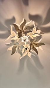 a chandelier with white flowers on a ceiling at Castelo Pink Boutique Hotel in Uruau