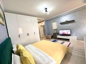 ein Schlafzimmer mit einem Bett und einem TV an der Wand in der Unterkunft Nice apartment in Militari Residence in Roşu