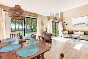 uma sala de estar com uma mesa de madeira com placas azuis em 3050 Club Villas em Amelia Island