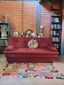 un sofá rojo sentado en una habitación con una alfombra en Pousada Villa Morena en Florianópolis