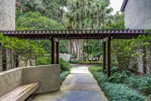 a wooden pergola over a walkway in a garden at 2349 Courtside Villas in Amelia Island