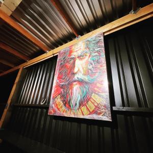 a painting of a man with a beard on a wall at Villas Quijote Valle de Guadalupe in Bonito