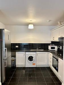 cocina con armarios blancos y lavadora en Modern Apartment X91 R940 en Waterford