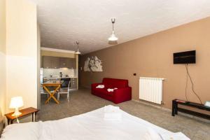 uma sala de estar com um sofá vermelho e uma cozinha em CasaJaky em Sauze d'Oulx