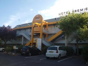a hotel with cars parked in a parking lot at Premiere Classe Beziers in Béziers