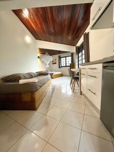 1 dormitorio con 1 cama con techo de madera en Villa Clémence, en Le François
