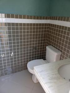 uma casa de banho com um WC branco e um lavatório. em housecabofrio em Cabo Frio