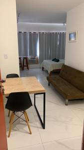 a living room with a table and a couch and a bed at Apartamento Princesa Isabel in Salvador