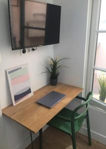 einen Holzschreibtisch mit einem Laptop und einem Stuhl in der Unterkunft Le Mini Montesquieu Studio Cosy 2 pers in Lyon