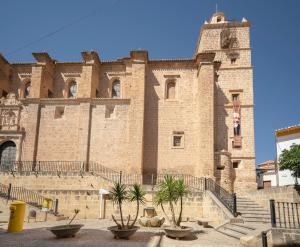 Un grand bâtiment en briques avec des escaliers se trouve juste devant. dans l'établissement Casa Fernandez de Cordoba en Illora, à Illora