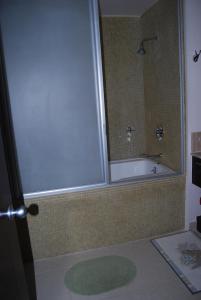ein Bad mit einer Badewanne und einer Dusche mit einem Spiegel in der Unterkunft Casa Adams Torre 13-202 Mayan Lakes Resort in Playa Encanto