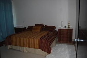 ein Schlafzimmer mit einem Bett und einer Holzkommode in der Unterkunft Casa Adams Torre 13-202 Mayan Lakes Resort in Playa Encanto + 21 Fotos