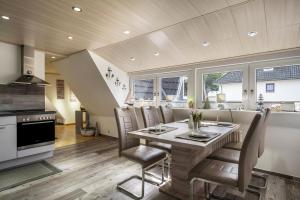 a kitchen and dining room with a table and chairs at Ankerplatz Maria Ratekau in Ratekau