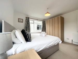 a bedroom with a large bed with white sheets and pillows at Bright Bungalow with 3 bedrooms and Garden in Porthlevan in Porthleven