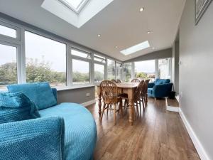 a living room with a couch and a table and chairs at Bright Bungalow with 3 bedrooms and Garden in Porthlevan in Porthleven