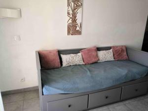 - un canapé avec des oreillers dans l'établissement Appartement T2 - Golf de Fontcaude - Résidence Coté Green à Juvignac 34990, à Juvignac