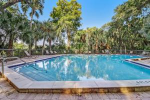 a swimming pool with trees in the background at 2123 Beach Wood in Amelia Island