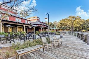 a wooden boardwalk with chairs and tables in front of a restaurant at 2123 Beach Wood in Amelia Island