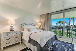 a bedroom with a bed and a large window at 1380 Shipwatch in Amelia Island +45 photos