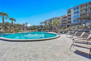 a swimming pool with chairs and a resort at 1380 Shipwatch in Amelia Island